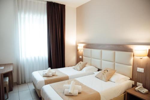 a hotel room with two beds and a window at Hotel St. Giorgio in Castel San Giorgio