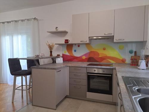 a kitchen with white cabinets and a counter top at Apartment Rita in Dramalj