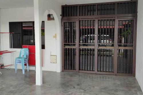 a pair of blue chairs sitting in front of a door at NTC Homestay at Parit Buntar in Parit Buntar