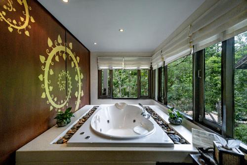 Suuko Wellness & Spa Resort في تشالونج: حوض استحمام كبير في غرفة مع نوافذ