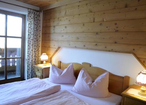 - une chambre avec un lit et un mur en bois dans l'établissement Laimer Urschlag, à Strobl