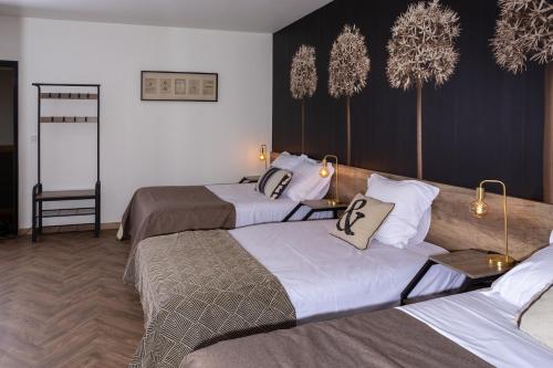 una habitación de hotel con 3 camas en una habitación en L'Aparté en Salles