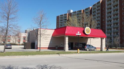 a gas station with a red roof in front of a building at Canad Inns Destination Centre Fort Garry in Winnipeg