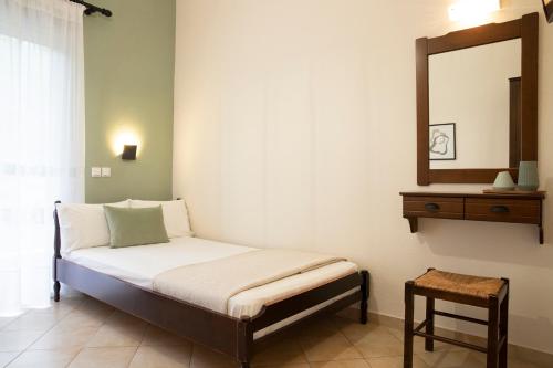 a small bed in a room with a mirror at Elena luxury living in Paralía Skotínis