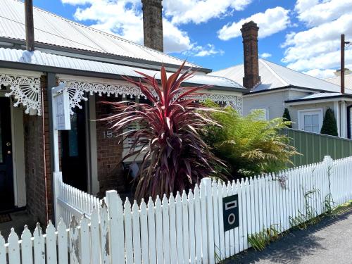 a white picket fence in front of a house at The Edward Townhouse 153 - Tastefully Styled in Orange