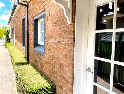a brick building with a door and a window at The Edward Townhouse 157 - Steps to Town in Orange