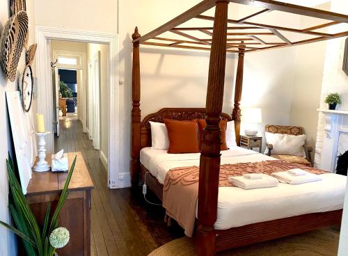 a bedroom with a bed with a wooden canopy at The Edward Townhouse 157 - Steps to Town in Orange