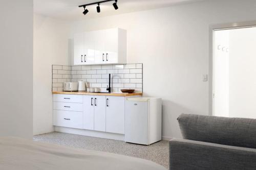 cocina blanca con armarios blancos y sofá en Scarborough Beach Break Holidays - Unit 4, en Scarborough