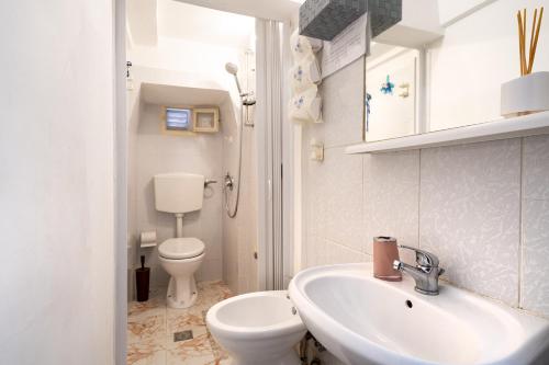 a white bathroom with a toilet and a sink at Chiarina rooms in Polignano a Mare
