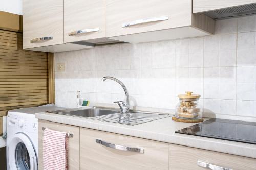a kitchen with a sink and a washing machine at Chiarina rooms in Polignano a Mare