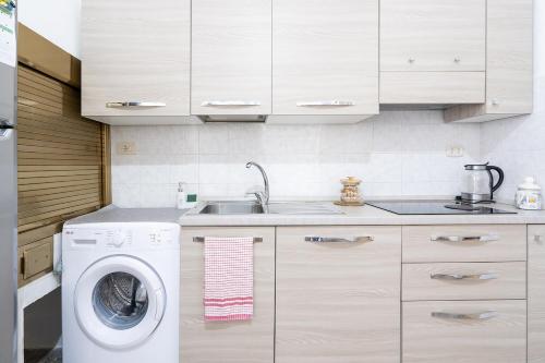 a kitchen with a washing machine and a sink at Chiarina rooms in Polignano a Mare
