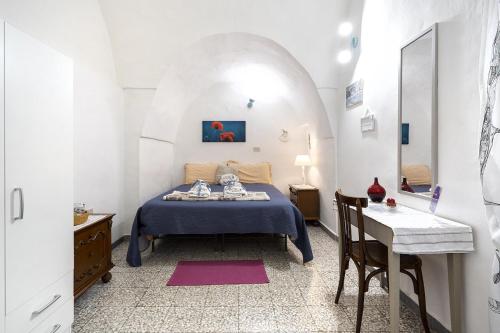 a bedroom with a bed and a table in a room at Chiarina rooms in Polignano a Mare