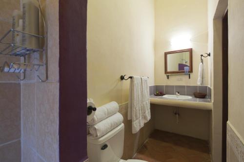 a bathroom with a toilet and a sink with a mirror at Hotel La Pérgola in Granada