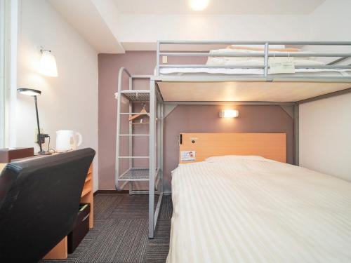 ein Schlafzimmer mit einem Etagenbett und einem Schreibtisch in der Unterkunft Super Hotel Kokuraeki Minamiguchi in Kitakyūshū