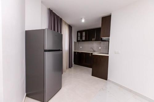 a kitchen with a stainless steel refrigerator and cabinets at Мезонет Пасажио in Sandanski