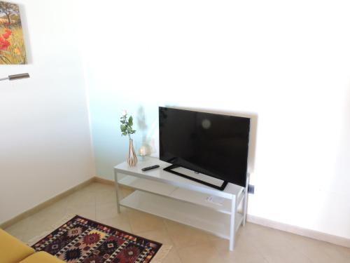 a living room with a flat screen tv on a white table at La casa di Marco e Lorella in Fratta Todina