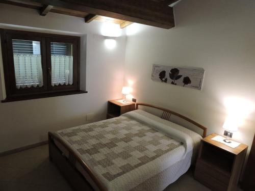 sypialnia z łóżkiem i dwoma lampkami na dwóch stołach w obiekcie La casa di Marco e Lorella w mieście Fratta Todina