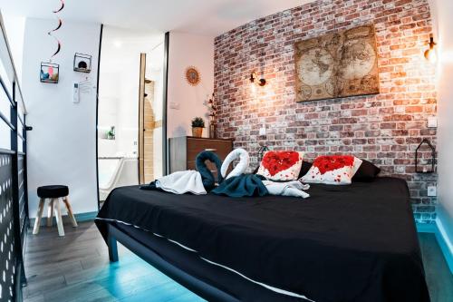 dwoje osób siedzących na łóżku w pokoju w obiekcie Love Loft Spa w mieście Ambronay