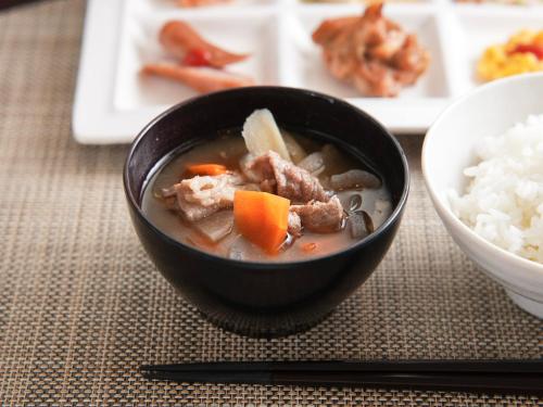 a bowl of soup with meat and carrots and rice at Super Hotel Kokuraeki Minamiguchi in Kitakyushu