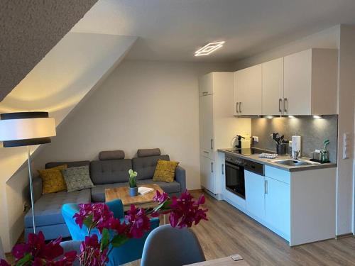 奥斯科卡爾斯哈根的住宿－Ferienwohnung Dominik，厨房以及带沙发和桌子的客厅。