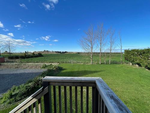 a balcony with a view of a field of grass at Pudding Hill Lodge & Chalets in Mount Hutt