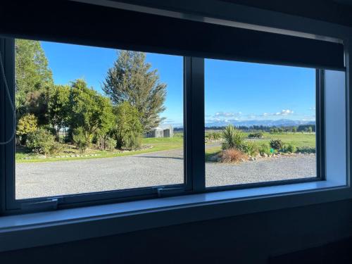an open window with a view of a road at Pudding Hill Lodge & Chalets in Mount Hutt