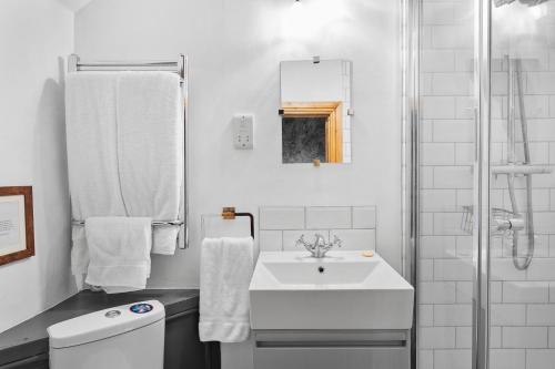 a white bathroom with a sink and a shower at Bellamarsh Farm B&B in Newton Abbot