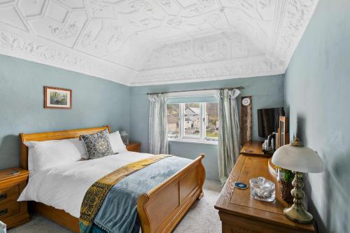 Schlafzimmer mit einem Bett, einem Tisch und einem Fenster in der Unterkunft Bellamarsh Farm B&B in Newton Abbot