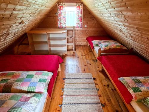 a room with two beds in a log cabin at Domki Pod Horbem in Polańczyk