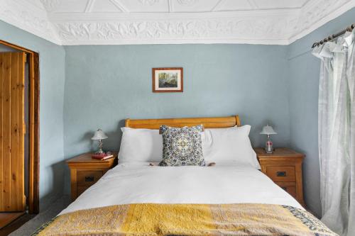 a bedroom with a large bed with blue walls at Bellamarsh Farm B&B in Newton Abbot