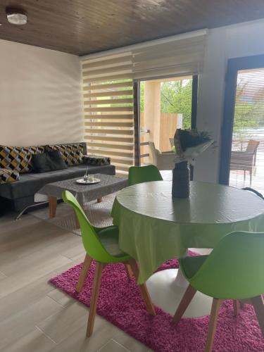 een woonkamer met een tafel en groene stoelen bij Apartment Vila Tara in Bihać