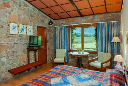 1 dormitorio con 1 cama, TV y mesa en Shikarbadi Hotel - Heritage by HRH Group of Hotels en Udaipur