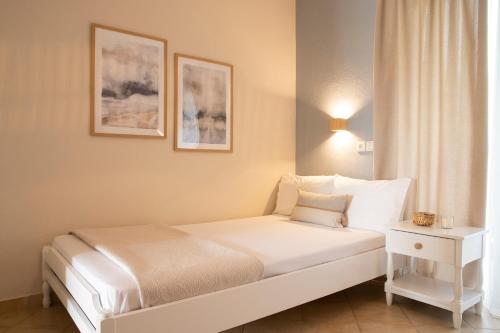 a bedroom with a white bed and a window at Elena luxury living in Paralía Skotínis