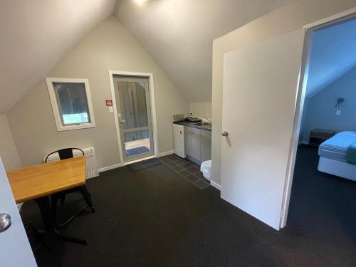 an attic room with a desk and a bedroom at Pudding Hill Lodge & Chalets in Mount Hutt