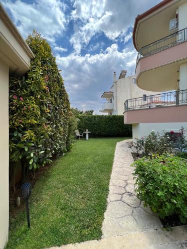 a yard next to a building with a hedge at Sunlight Experience in Artemida
