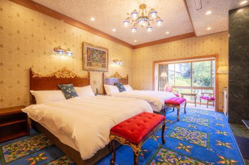 1 dormitorio con 2 camas y lámpara de araña en Hotel Sekifu, en Fuefuki