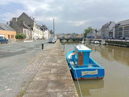a blue boat parked on the side of a river at Poisson in Isigny-sur-Mer