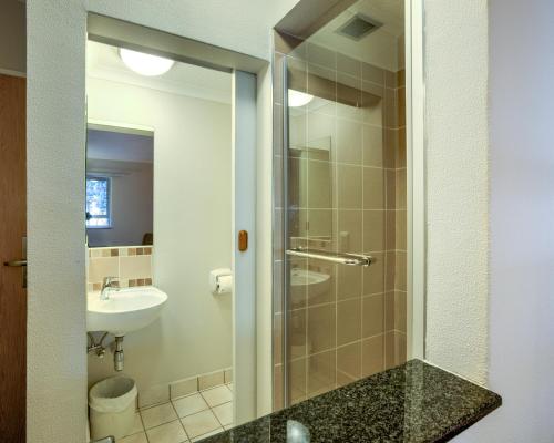 a bathroom with a shower and a sink at Road Lodge Germiston in Germiston
