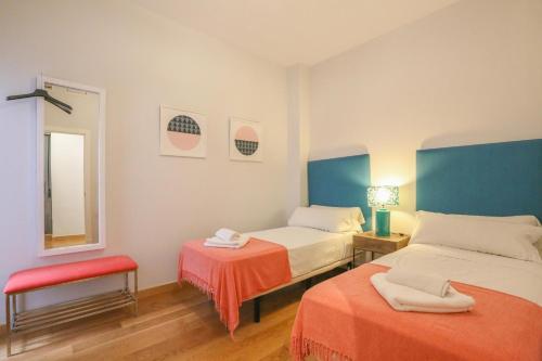 Cette chambre comprend 2 lits et un miroir. dans l'établissement Casa Piren, à Séville
