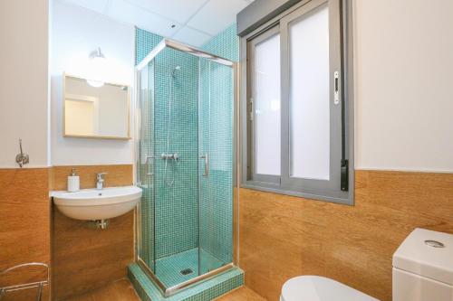 La salle de bains est pourvue d'une douche en verre et d'un lavabo. dans l'établissement Casa Piren, à Séville