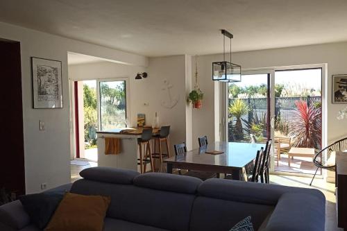un salon avec un canapé bleu et une table dans l'établissement Maison entre Terre & Mer – Wifi, à Loctudy