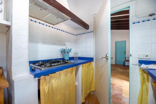 a kitchen with a stove and a blue counter top at Ponent in Es Caló