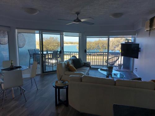 a living room with a couch and a view of the water at Sandy Shores Holiday Units in Caloundra