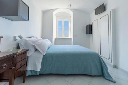 a white bedroom with a bed and a window at Albergo La Prora in Capri