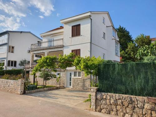 a white house with a fence in front of it at Vila Beleca Krk - Apartments Rest & Sea in Krk