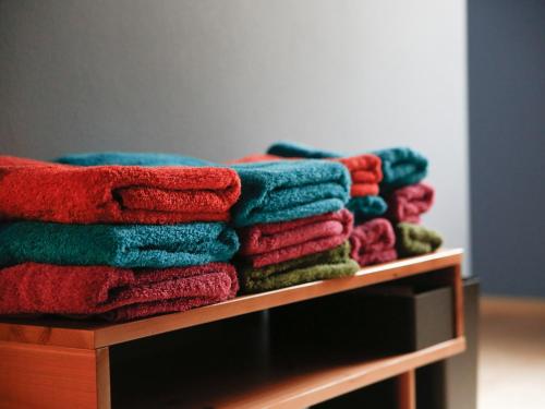stos kolorowych ręczników na półce w obiekcie Temari Inn Madoromi w mieście Kurashiki
