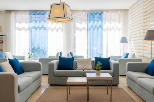 a living room with couches and blue pillows at Hotel Doria in Cavi di Lavagna