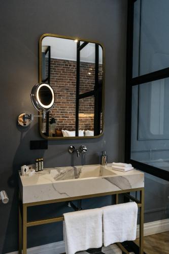 a bathroom with a sink and a mirror at Gruner Hotel in Lviv