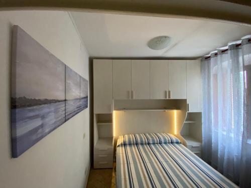 a bedroom with a bed and a painting on the wall at Luisa Solferino 2 in Porto Azzurro