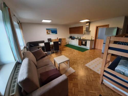 salon z kanapą i kuchnią w obiekcie Schöne Wohnung am Bauernhof 